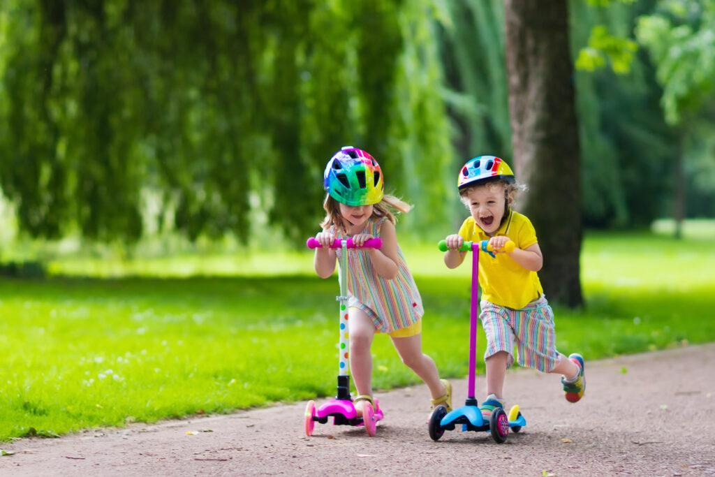 Kinder fahren mit bunten Rollern.