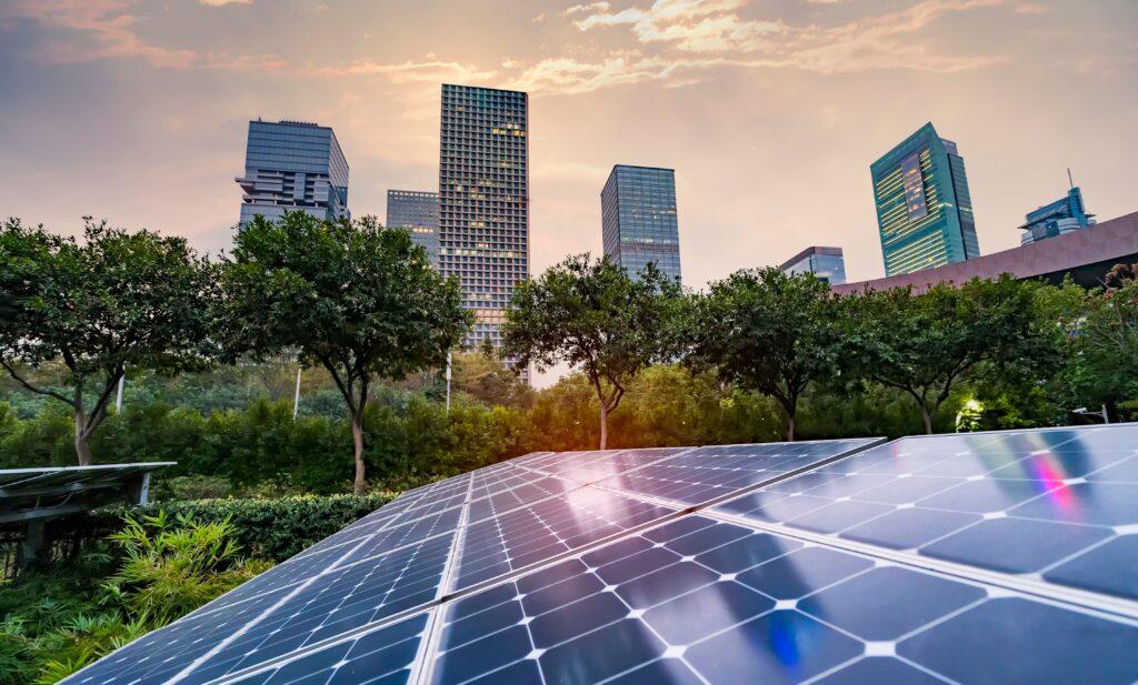 Eine Photovoltaik Anlage, wo im Hintergrund eine Stadt zu sehen ist