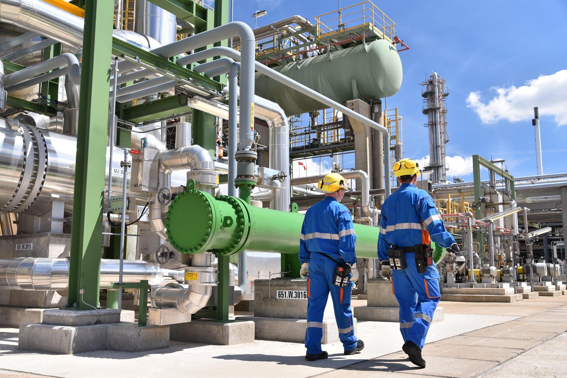 Zwei Mitarbeitende kontrollieren technische Anlage | Chemieschläuche