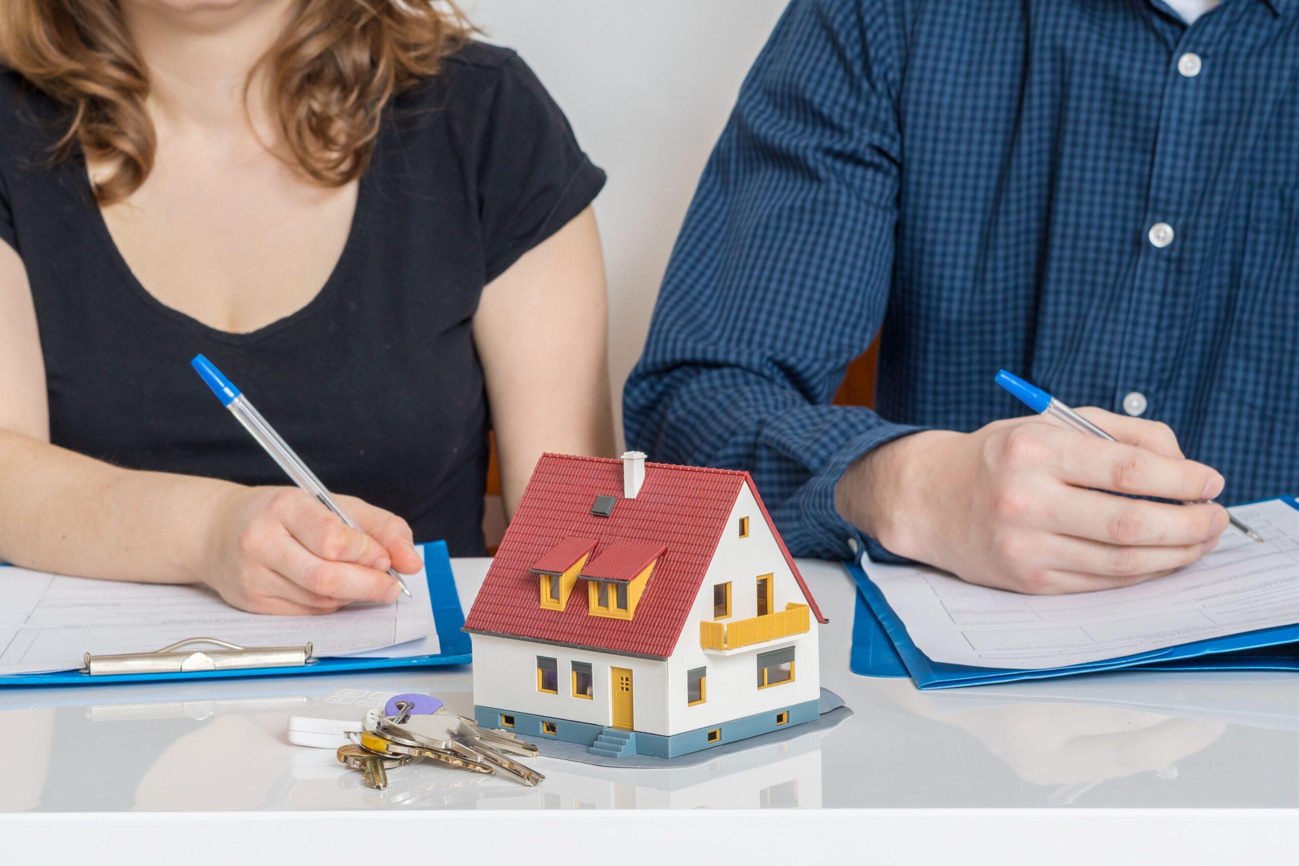 Scheidung Kosten bei Immobilienaufteilung – zwei Personen unterschreiben Unterlagen