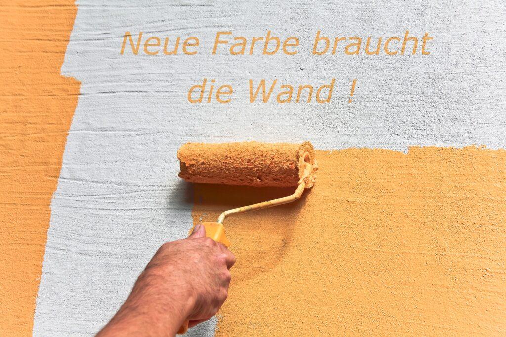 Farbrolle streicht Wand orange | Street Art Künstler