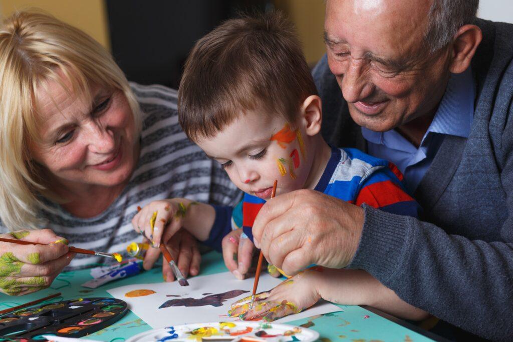 Grosseltern malen lachend mit Enkelkind | Wohnungssanierung Berlin