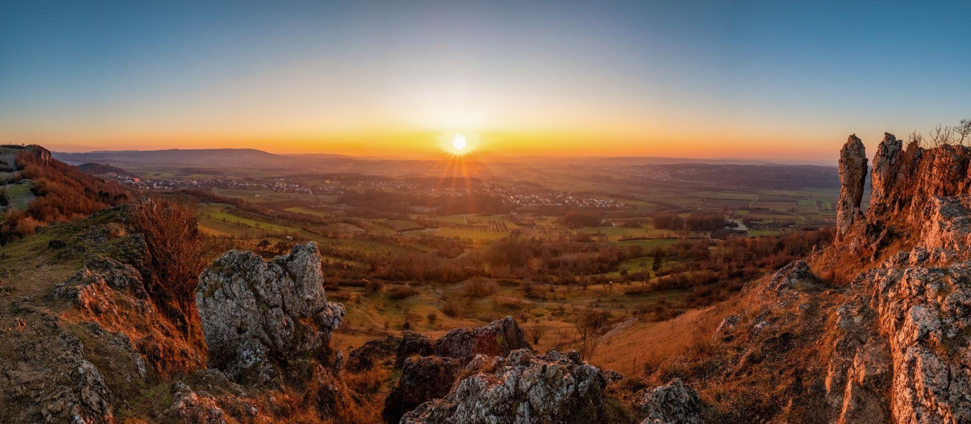 Panorama der Fraenkischen Schweiz bei Sonnenuntergang mit Felsen und weitem Talblick, Symbol fuer Ruhe und Naturverbundenheit